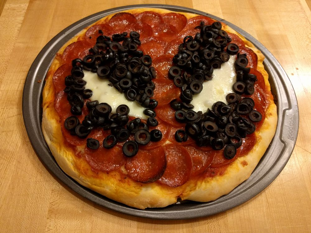 A pepperoni pizza made to look like Deadpool's mask.