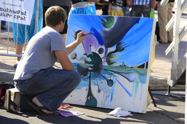 A man painting abstract art on canvas