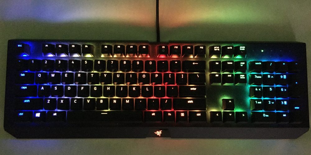 A close-up of the Razer BlackWidow X Chroma, in wave setting, having rainbow waves of light across its keys.