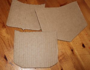 Cut square pieces of corrugated cardboard or pasteboard, and shape to resemble little car hoods. Image: Lisa Kay Tate