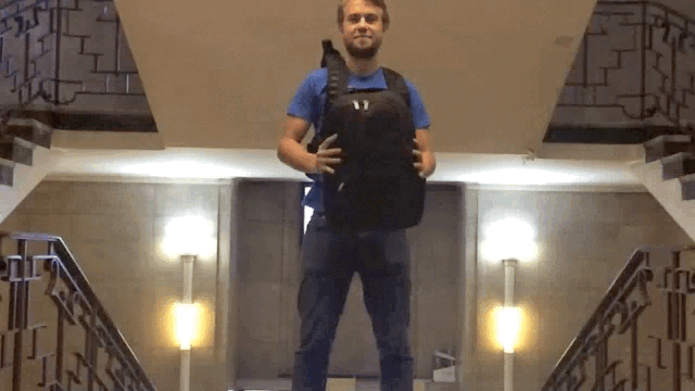 A man swings a backpack around him.