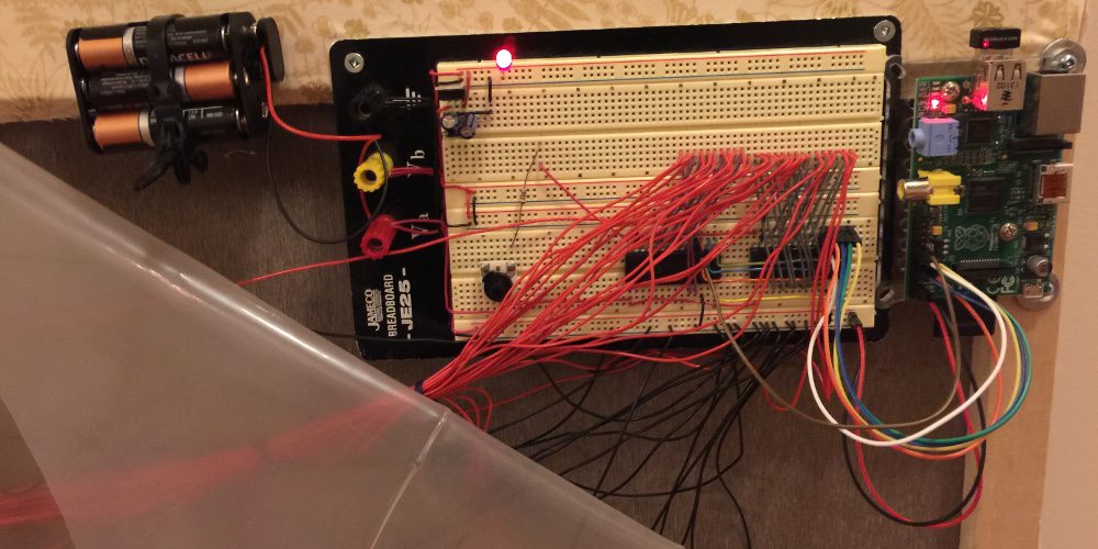 The complete Stranger Things Ouija Wall circuit wired on a breadboard and Raspberry Pi, attached on the back of the portable wall along with a 9 volt power supply.