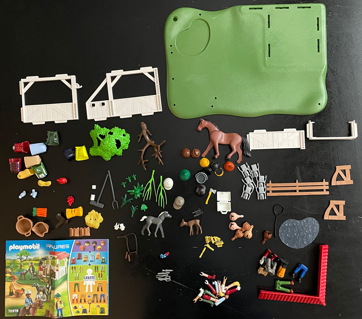 All parts of Horse Ranch set laid out on table.